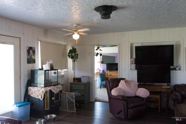 2771 S 850 E, Hagerman, ID 83332 - living room featuring wood finished floors, a textured ceiling, a ceiling fan, and wooden walls