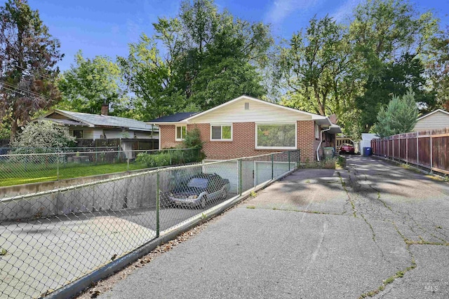 ranch-style home with a fenced front yard and brick siding