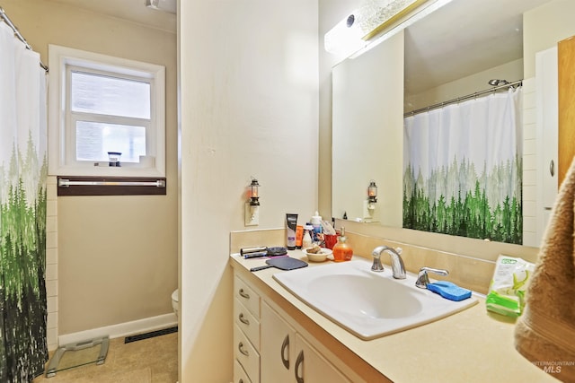 bathroom with toilet, a shower with curtain, vanity, and baseboards