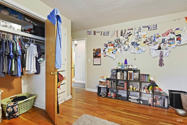 bedroom with a closet, baseboards, and wood finished floors
