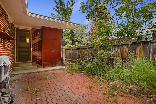 exterior space featuring brick siding and fence