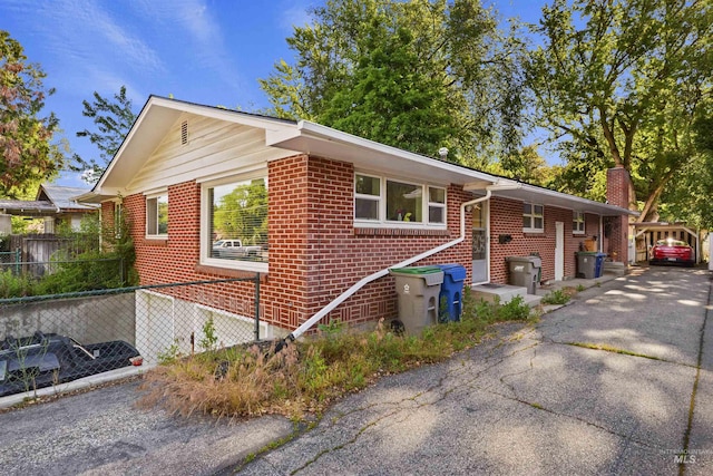 view of property exterior featuring brick siding, fence, and a chimney