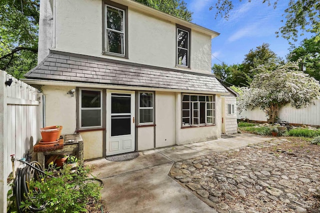 back of house featuring a patio area, stucco siding, and fence