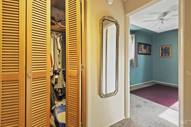 hallway featuring baseboards and carpet flooring