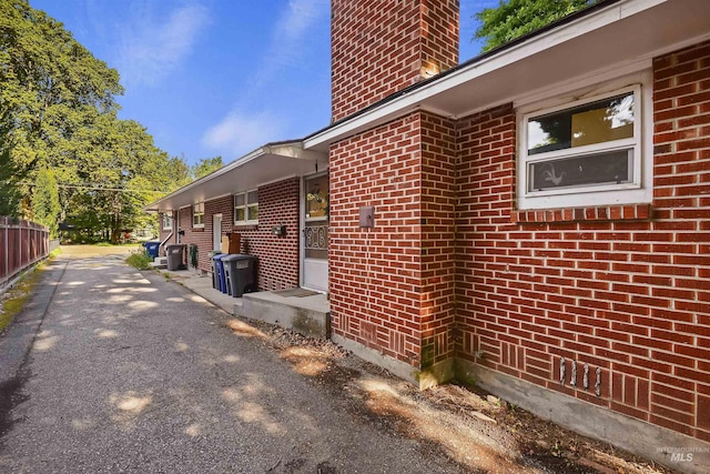 view of home's exterior with brick siding and a chimney