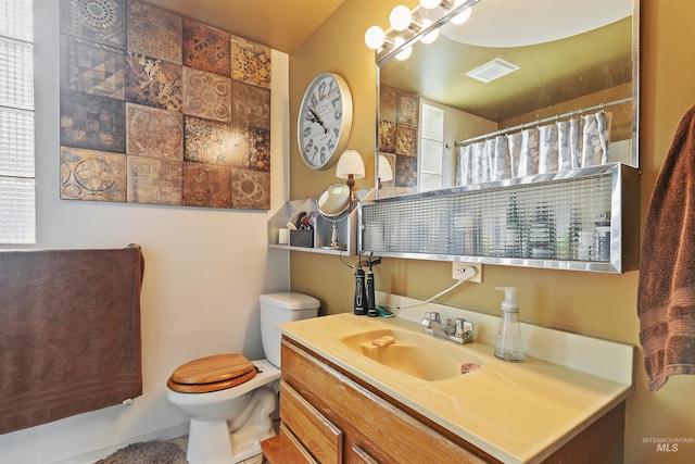 full bath featuring toilet, curtained shower, and vanity
