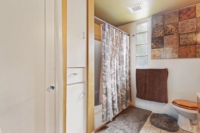 bathroom with visible vents, toilet, a shower with curtain, and tile patterned floors
