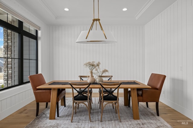 dining area with recessed lighting, ornamental molding, a raised ceiling, and wood finished floors