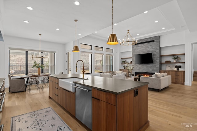 kitchen featuring dark countertops, built in shelves, an inviting chandelier, modern cabinets, and stainless steel dishwasher