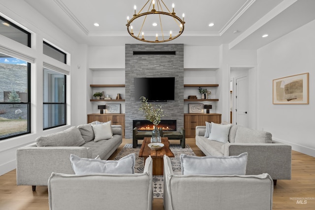 living room featuring light wood-style flooring, ornamental molding, and a large fireplace