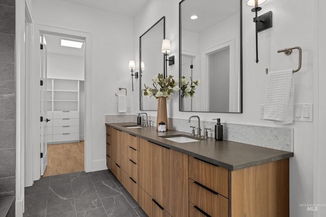 full bathroom with double vanity, backsplash, and a sink