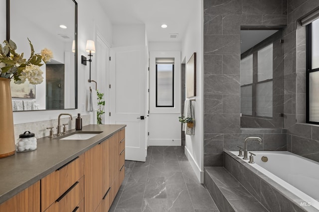 full bathroom featuring visible vents, a garden tub, marble finish floor, baseboards, and vanity