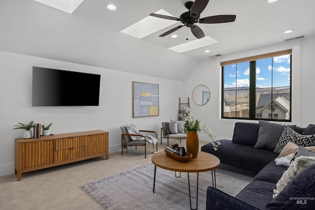 carpeted living area with recessed lighting, visible vents, vaulted ceiling with skylight, and ceiling fan