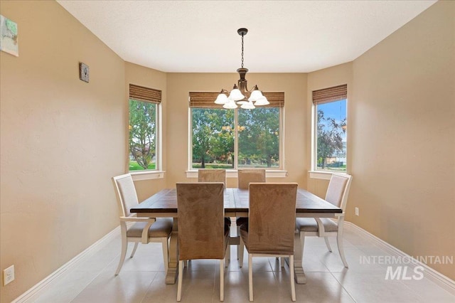 tiled dining room featuring a healthy amount of sunlight and a chandelier