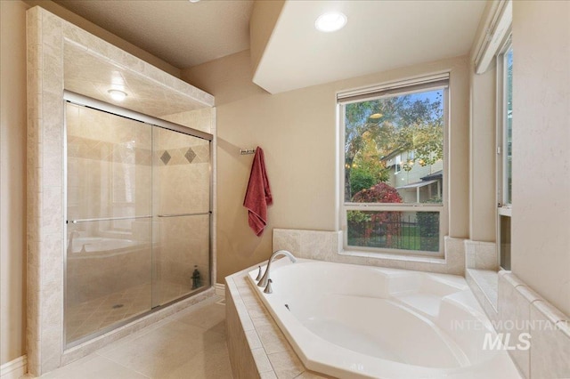 bathroom featuring tile patterned flooring and separate shower and tub