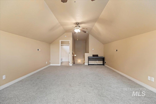 additional living space featuring vaulted ceiling, carpet, a textured ceiling, and ceiling fan