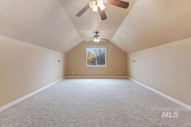 additional living space with lofted ceiling, light colored carpet, and a textured ceiling