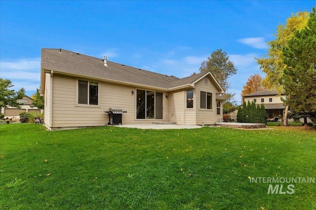 rear view of property featuring a patio area and a lawn