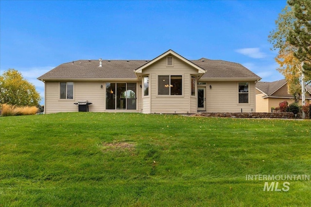 back of property featuring a lawn