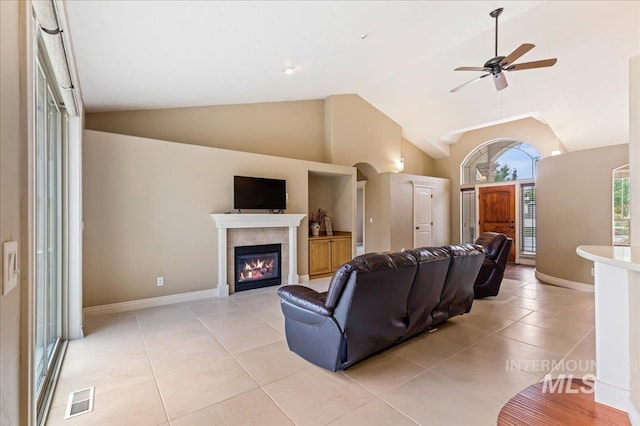 living room with a fireplace, high vaulted ceiling, and light tile patterned flooring