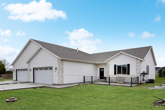 view of front of property featuring central AC, a garage, and a front yard