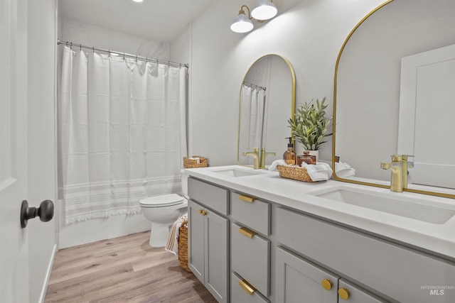 full bathroom featuring wood-type flooring, shower / bath combination with curtain, toilet, and double sink vanity