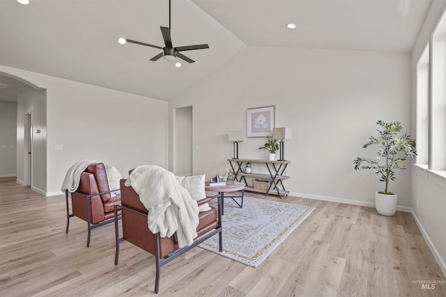 living room featuring high vaulted ceiling, light hardwood / wood-style flooring, and ceiling fan