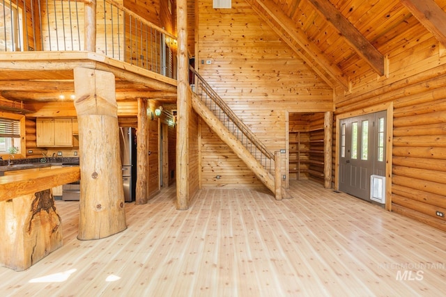 unfurnished living room with wooden ceiling, stairway, beamed ceiling, light wood-type flooring, and high vaulted ceiling