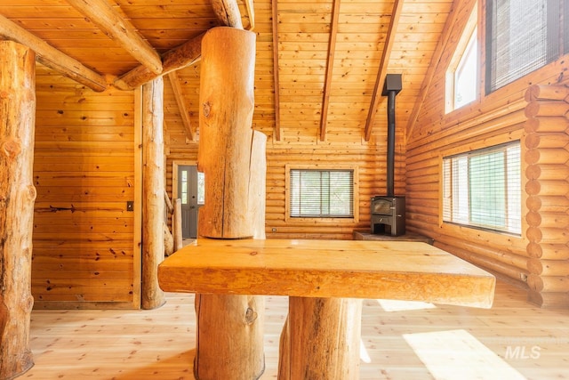 unfurnished living room featuring a wood stove, wooden ceiling, and beam ceiling