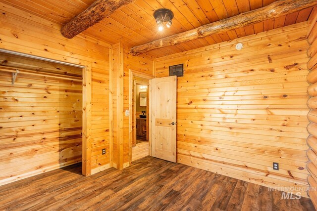 unfurnished bedroom with a closet, wood-type flooring, wooden walls, beamed ceiling, and wood ceiling