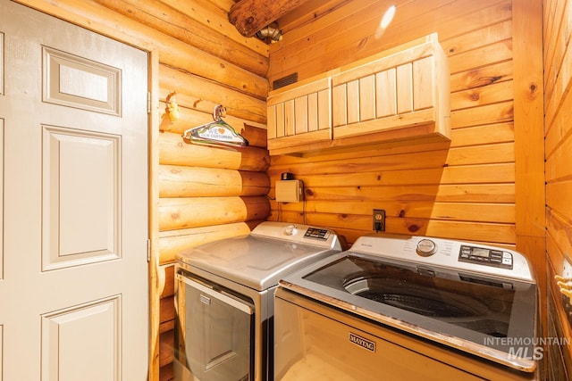 laundry room featuring separate washer and dryer and log walls