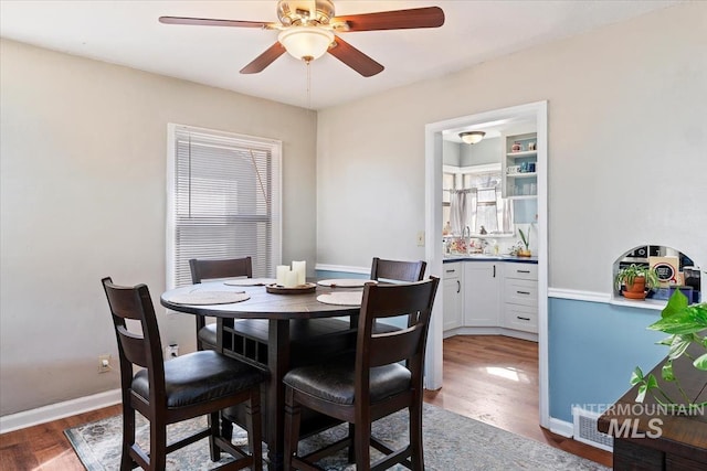 dining room featuring baseboards, ceiling fan, and wood finished floors