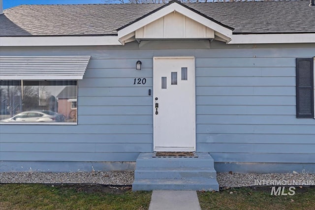 property entrance featuring roof with shingles