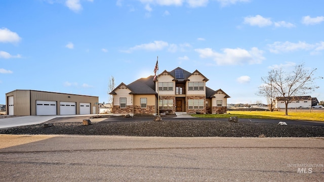 view of front of home featuring an outdoor structure, a garage, and stone siding