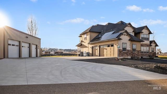 exterior space featuring a garage, central air condition unit, solar panels, and driveway