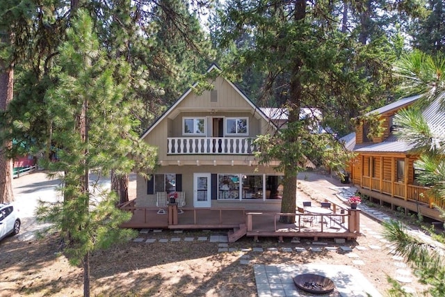 back of house featuring an outdoor fire pit and a wooden deck