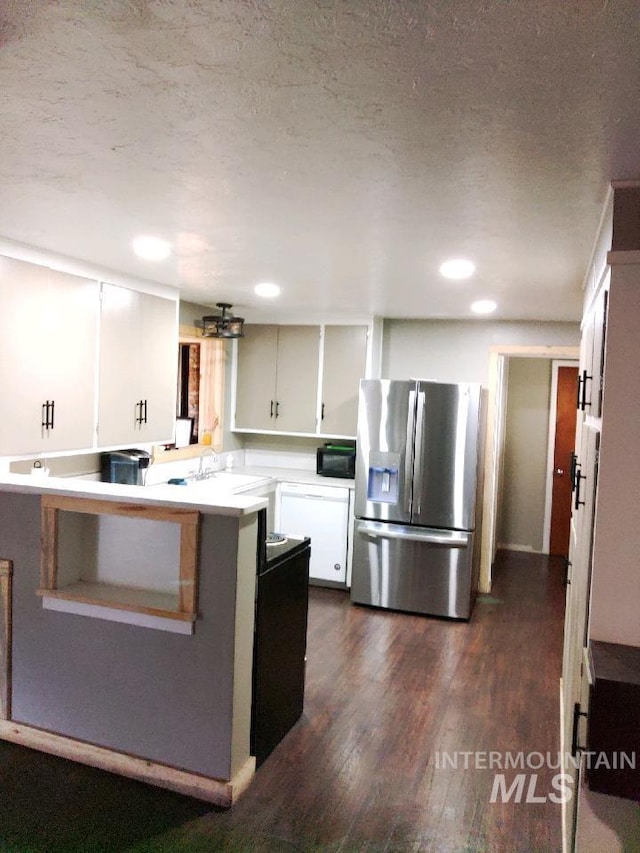 kitchen featuring stainless steel fridge, kitchen peninsula, a textured ceiling, white cabinetry, and dark hardwood / wood-style flooring