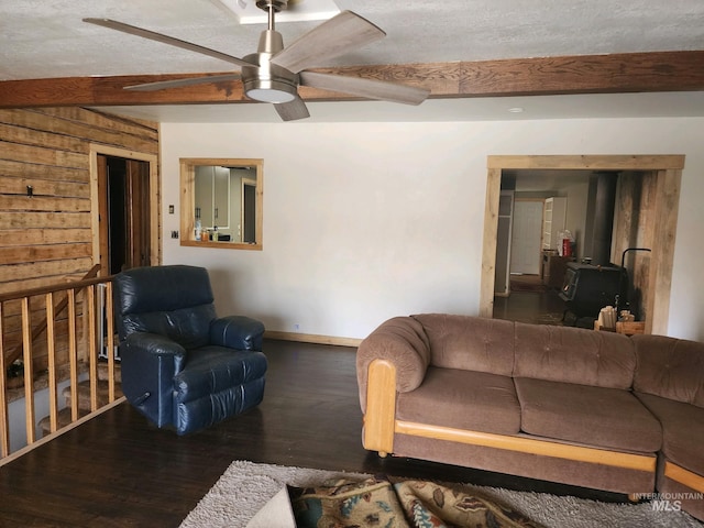 living room featuring beamed ceiling, dark wood-type flooring, a textured ceiling, and ceiling fan