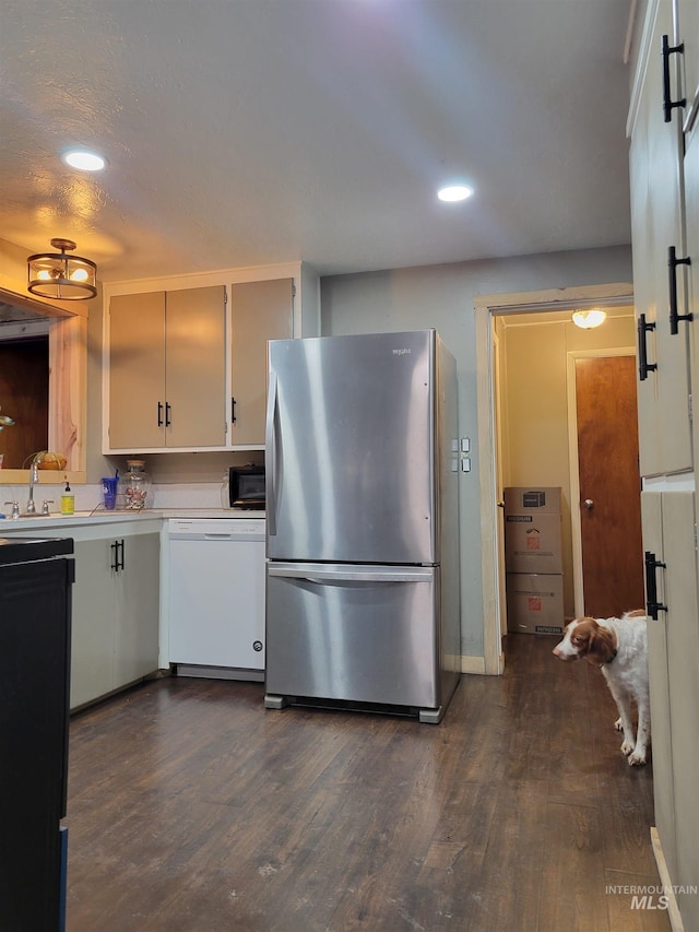 kitchen featuring stainless steel refrigerator, white cabinets, white dishwasher, dark hardwood / wood-style floors, and sink