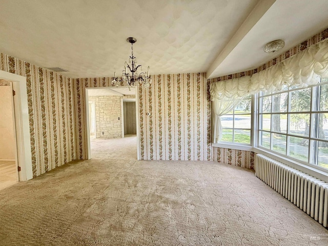 unfurnished dining area featuring radiator heating unit, wallpapered walls, carpet flooring, and a chandelier