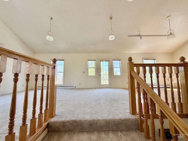 staircase with carpet, lofted ceiling, healthy amount of natural light, and a textured ceiling