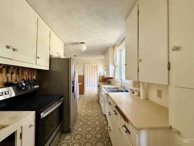 kitchen featuring stainless steel appliances, a sink, light countertops, and white cabinetry