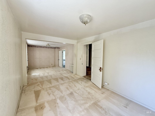 unfurnished room featuring light carpet
