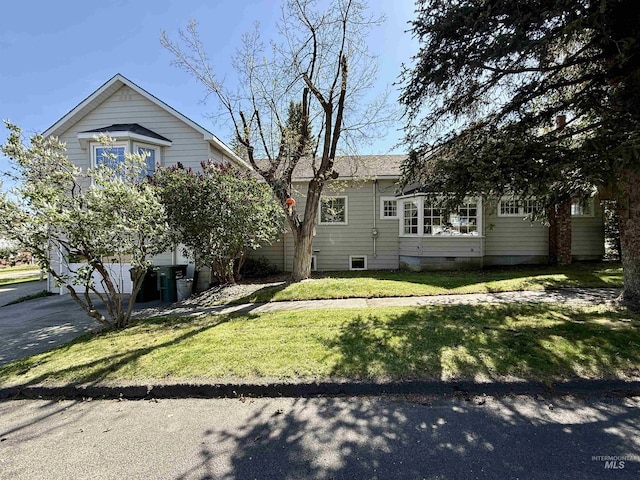 view of property hidden behind natural elements featuring a front yard