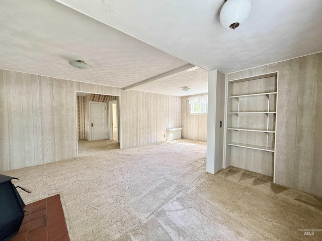 empty room with carpet flooring and a wood stove