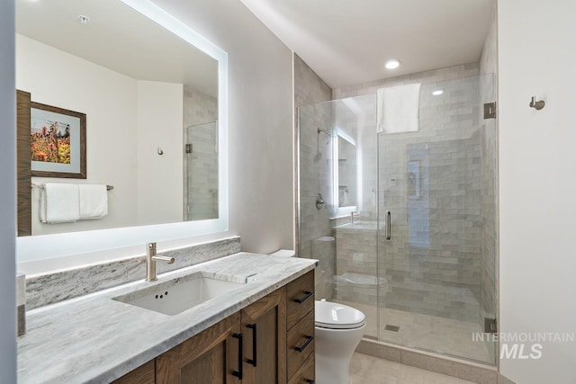 bathroom with vanity, an enclosed shower, and toilet