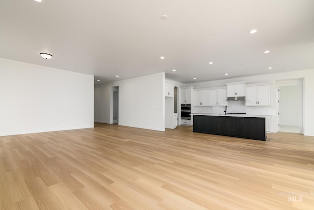 unfurnished living room with light wood-type flooring