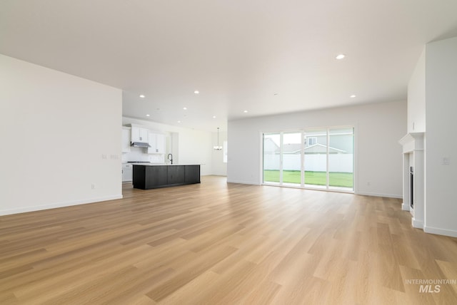 unfurnished living room featuring light hardwood / wood-style floors and sink