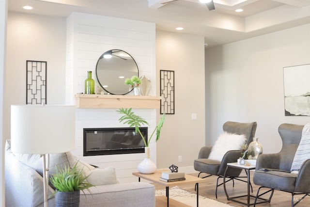 living area with a large fireplace and hardwood / wood-style floors