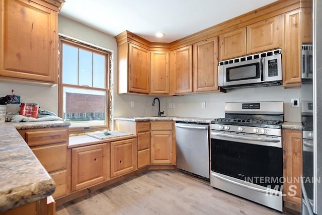 201 W A St, Vale, OR 97918 - kitchen with stainless steel appliances, light wood finished floors, light countertops, light brown cabinetry, and recessed lighting